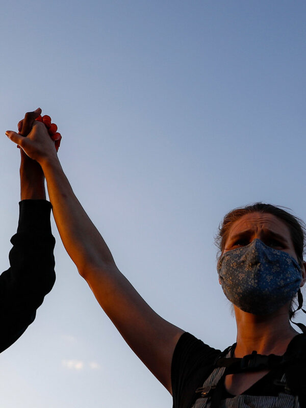 A man and a woman holding a sign reading "We can't Breathe"