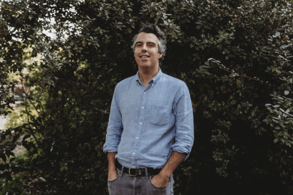 White male with gray hair wearing a denim shirt with jeans and black belt. The man has his hands in his pockets and is smiling. Text on the image reads, "Welcome Our New Legal Director, John C. Williams! "