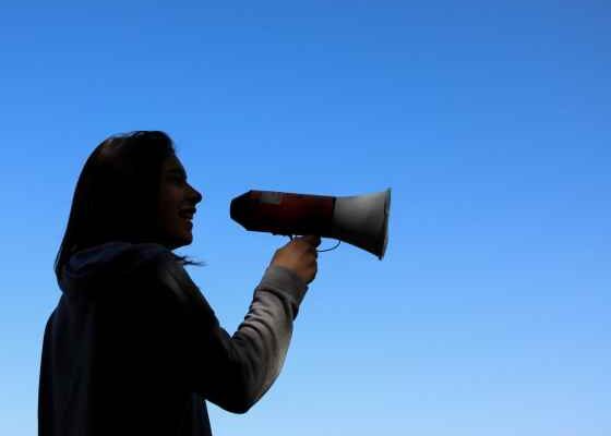 Person in shadows holding megaphone