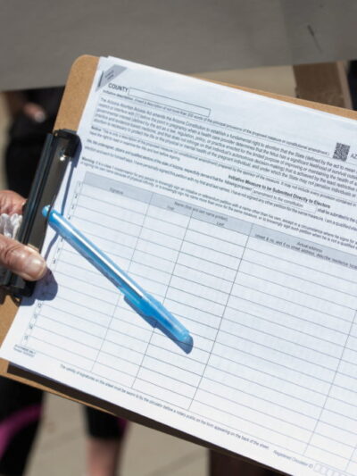A canvasser gathers a petition signature.