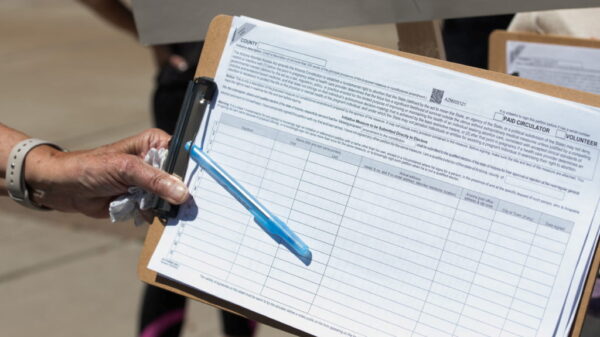 A canvasser gathers a petition signature.