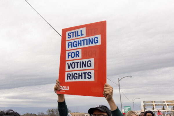 ACLU sign, blue text on white and red background reading, "Still Fighting for Voting Rights."