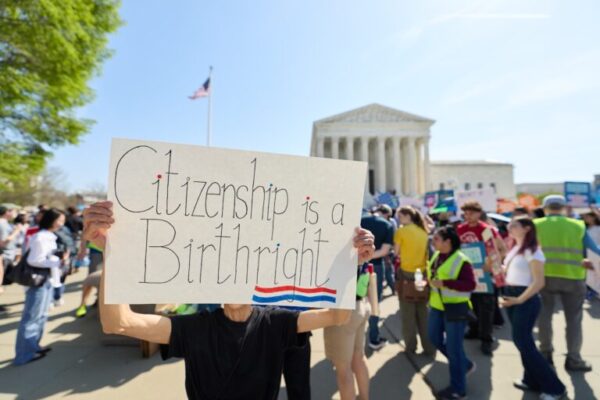 Person holding "Citizenship is a Birthright" sign