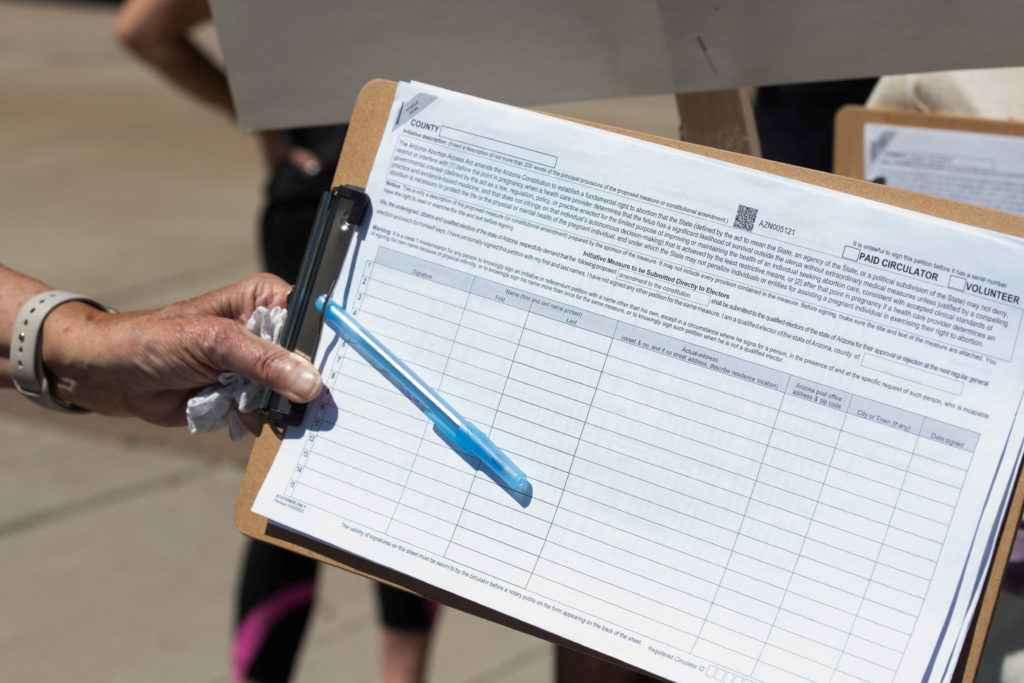 A canvasser gathers a petition signature.