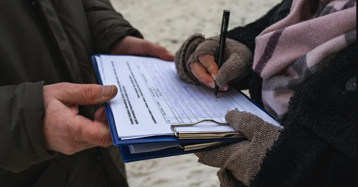 A canvasser gathers a petition signature.