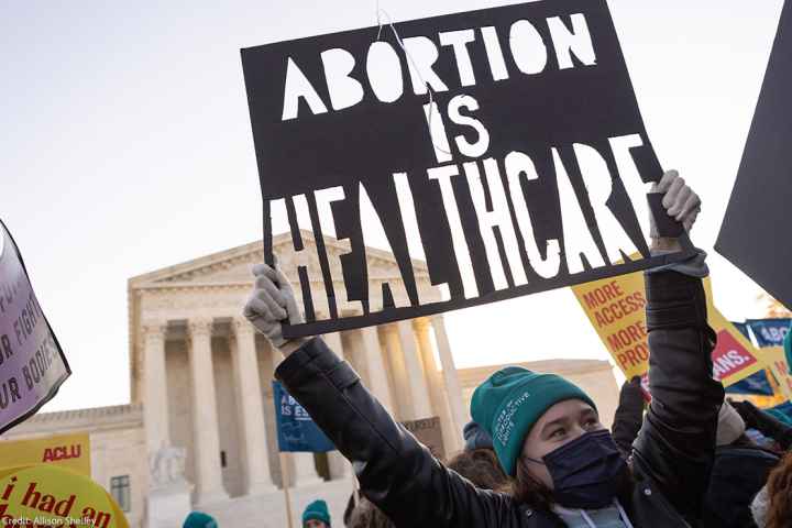 A person at a rally holding a sign that says “Abortion is Healthcare.”