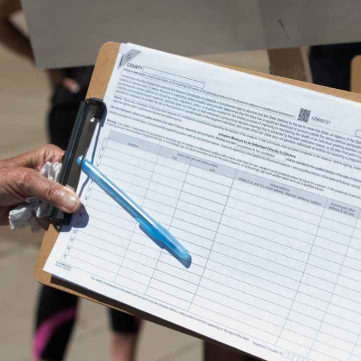 A canvasser gathers a petition signature.